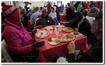 Picture of SSS' holiday meal - dozens of members sitting at tables eating together